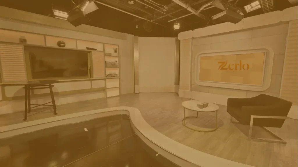 Photo of the studio where Zerlo is shot and recorded including a cozy chair, a coffee table and some lighting rigged on the ceiling.